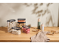 Transparent food containers with cereals, legumes, and nuts, with salt and pepper grinders.