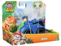 Toy figure of a puppy in a blue vehicle with a dinosaur, movie themed.