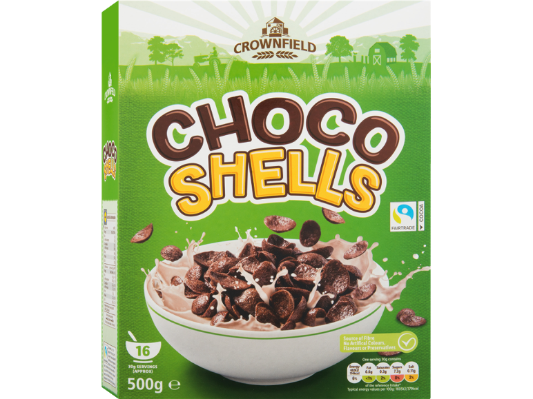 Green cereal box with chocolate shells in a bowl with milk.