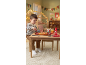 Child playing with toy pizza, toy drinks, and ketchup on the table.