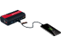 Portable power bank charging a smartphone, with a flashlight and multiple ports.