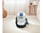 Carpet cleaner on a white rug in a bright living room.