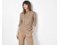 Woman in a beige ribbed long-sleeve top and beige trousers.