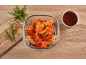 Marinated chicken wings in a glass dish with rosemary and sauce.