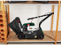 Green and black lawnmower with a grass bag on a shelf in a garage.