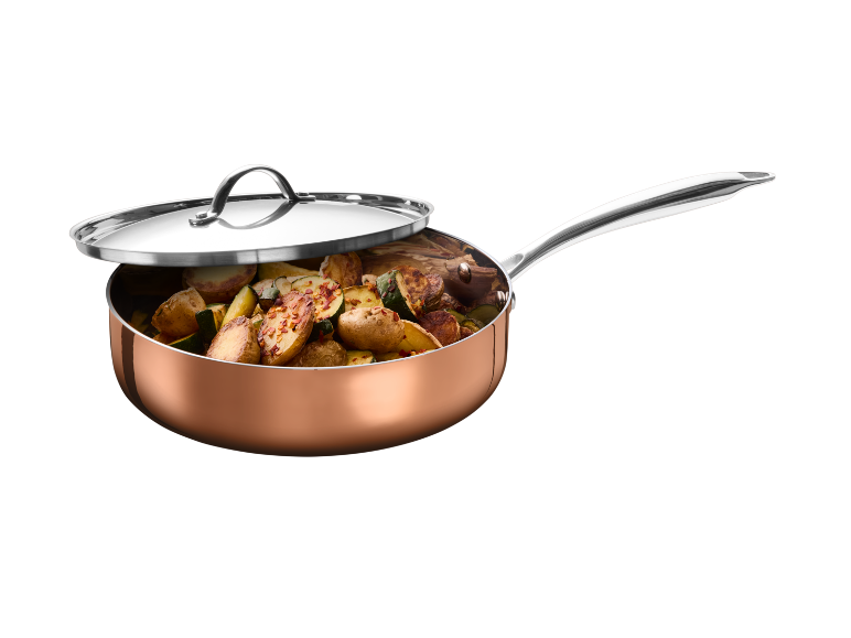 Copper pan with lid, filled with roasted potatoes and zucchini.