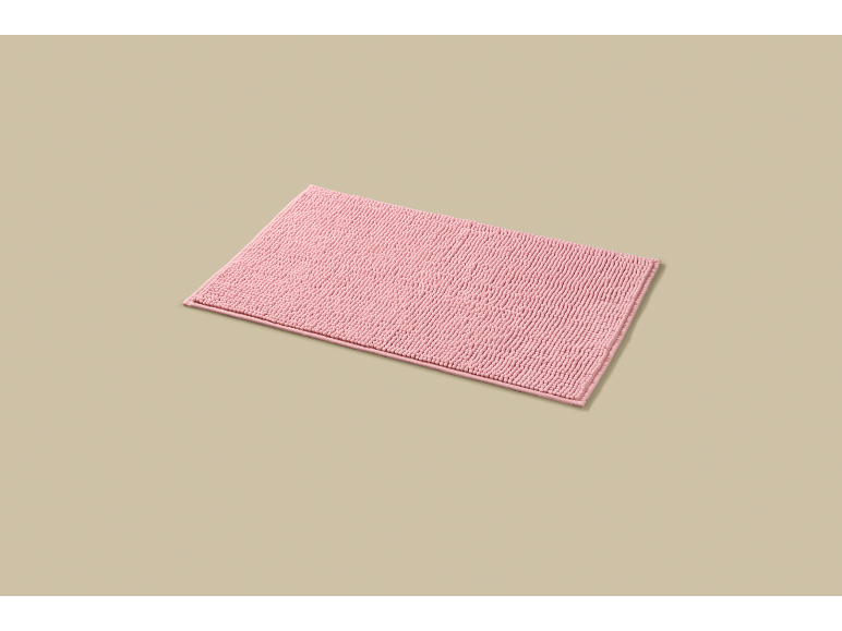 Pink bath mat on a beige background.