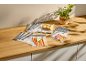 Vacuum bags with carrots, corn, and apples on a wooden countertop.