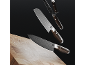 Three chef's knives with dark handles and Damascus pattern, a wooden cutting board.