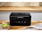Black bread bin with the number 1973 in a wooden kitchen with a sandwich.