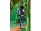 Child with blue backpack and jeans in a paper jungle setting.