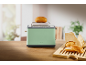 Toaster with a bun on top and buns on a wooden board.