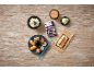 Overhead view of a sushi rice package, a sushi set, a bowl of rice, and ginger on a wooden table.