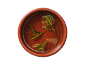 Fresh rosemary sprigs floating in olive oil in a terracotta bowl.