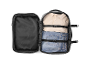 Open travel backpack with a beige shirt and blue jeans inside.