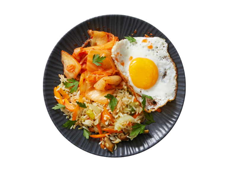 Fried rice with kimchi and a fried egg on a dark plate.