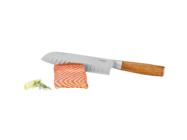 Kitchen knife with wooden handle, fresh salmon, and lemon with dill.