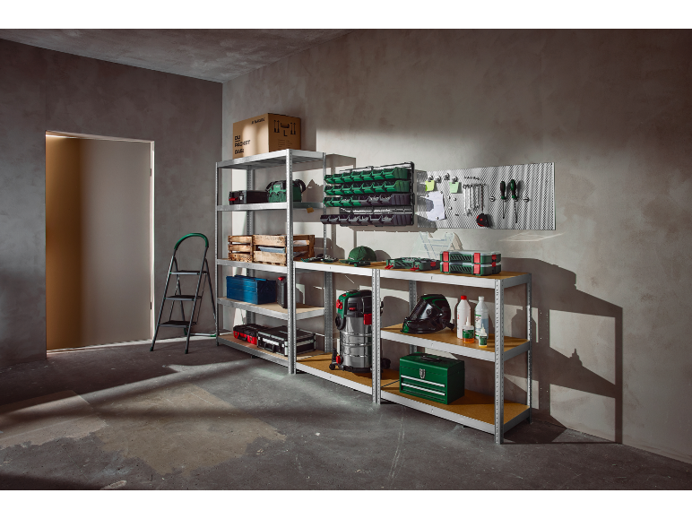 Garage or workshop with shelving units, tools, storage boxes, and a vacuum cleaner.