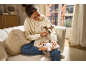 Woman petting dog on sofa, with puppy plush toy on lap.