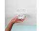 Hand holding a smoke detector, ready for ceiling installation.