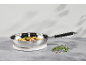 Stainless steel pan with vegetables and meat on a grey table