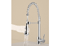 Chrome kitchen faucet with pull-out spray head and spring design, a hand holds the spray head spouting water.