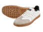 White sneakers with a suede toe and brown sole, one flipped over.