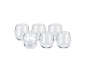 Set of six clear stemless glasses, one filled with ice and sparkling water.