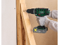 A cordless drill driver inserts a screw into a wooden beam.