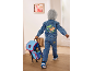Boy in a dinosaur denim jacket and jeans, carrying a blue backpack.