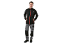 Man in black softshell jacket and grey work trousers with black details.