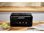 Black bread bin with the number 1973 in a wooden kitchen with a sandwich.