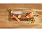Chef's knife, salmon fillets, lemons, and herbs on a wooden cutting board.