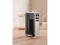Black hand mixer with silver details on a wooden kitchen counter.