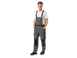 Smiling man in grey and white work overalls with safety shoes.
