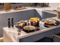 Copper pots and pans on an induction hob, with food and kitchen accessories.
