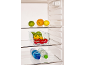 Open refrigerator with fruits, vegetables in a container, and water bottles.