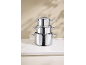 Stacked stainless steel pots and pans with lids on a white marble surface.