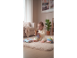 Smiling baby playing with a capybara plush toy, a fabric book, and a fabric ball.