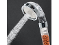 Filtering shower head with a strong water jet and visible mineral balls.