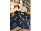 Manicure and pedicure tools on a dark blue towel with beauty products in the background.
