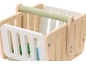 Children's wooden shopping basket with a green handle and white sides.
