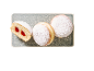 Doughnuts with powdered sugar, one cut open with strawberry jam.