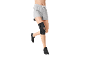 Woman in grey shorts and black knee brace running.