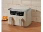 Cream dual-basket air fryer with digital display showing 14:55 and 23:20, next to fries.