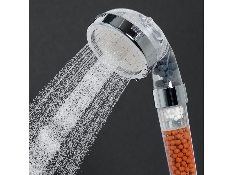Filtering shower head with water jets and visible mineral beads.