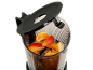 Fruit pieces in a blender, including orange, apple, and mango, with the lid open.
