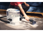 Person cleaning a carpet with a carpet cleaner.