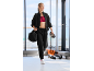 Woman in black tracksuit and red sports bra, with a bag and water bottle.