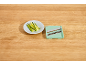 Julienned zucchini on a plate next to a mandoline slicer.
